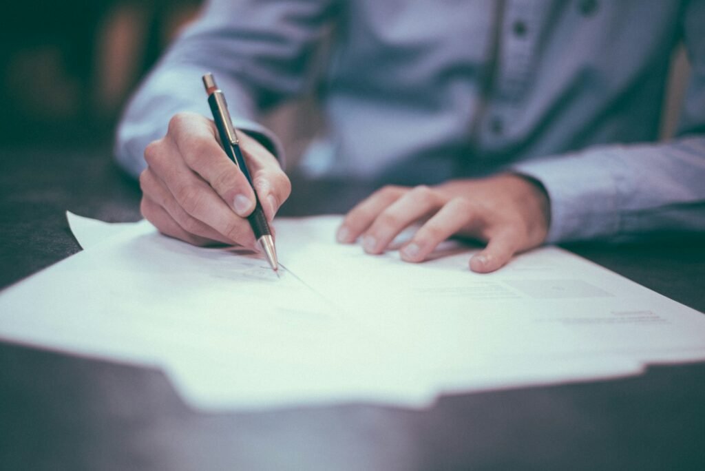 Hand writing on a printed contract document with a pen