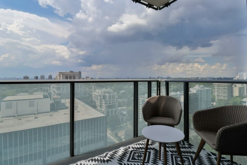 Apartment balcony with outdoor seating overlooking a city skyline