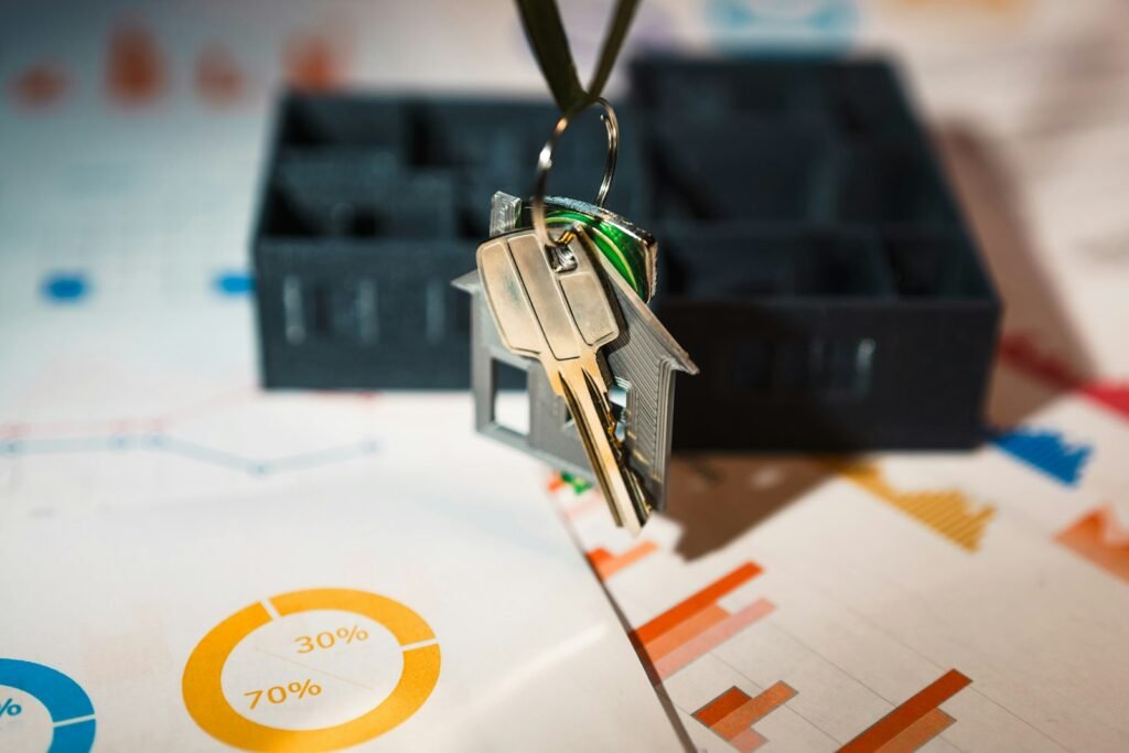 House-shaped keyring beside charts representing property finance statistics