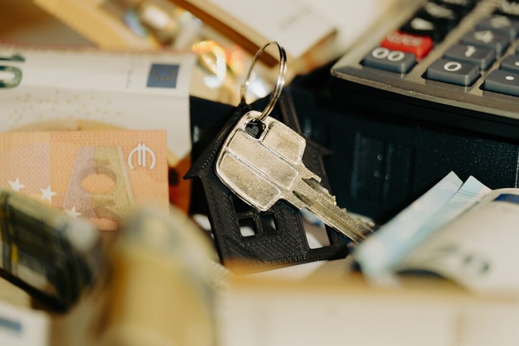 House keys beside a calculator and cash, representing the cost of moving between homes