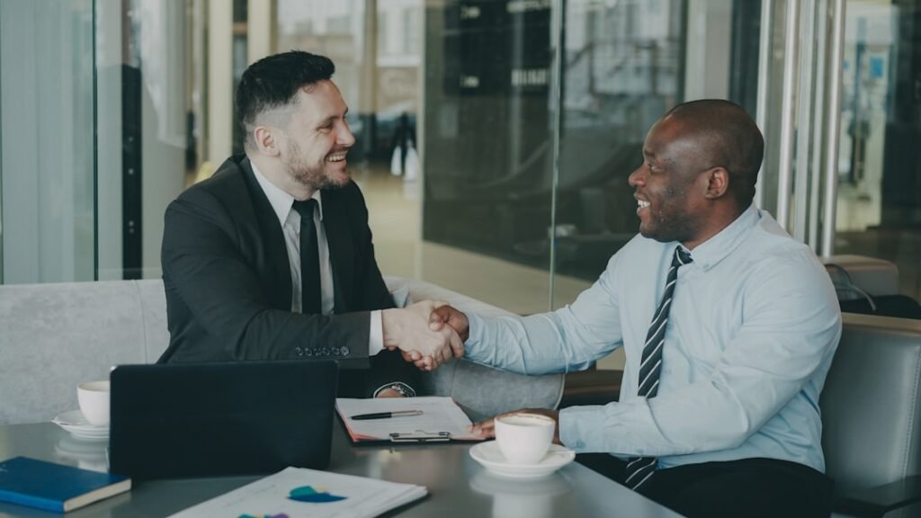 Two people reviewing a contract and notepad across a table before signing