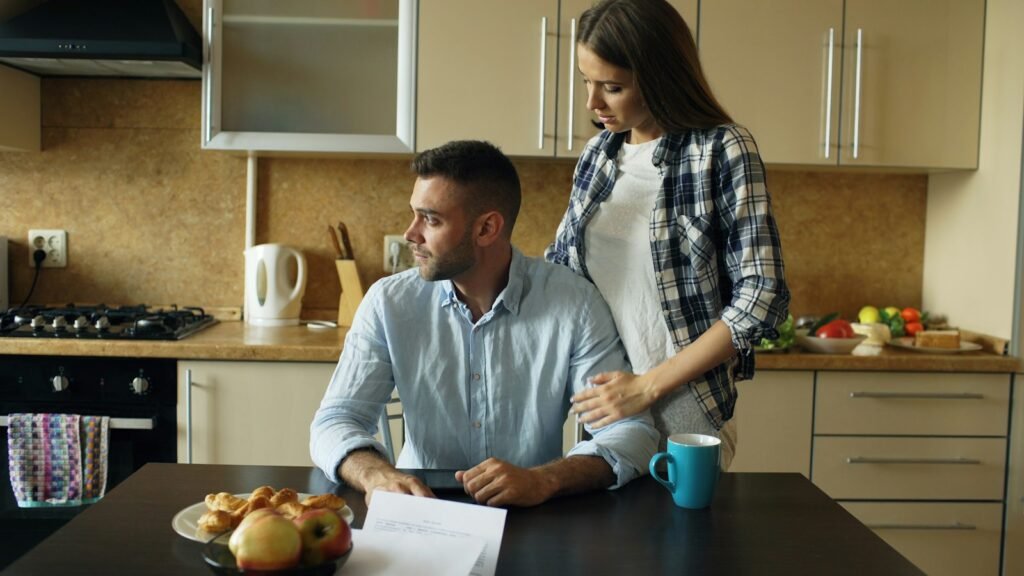 Couple reviewing paperwork at a kitchen table