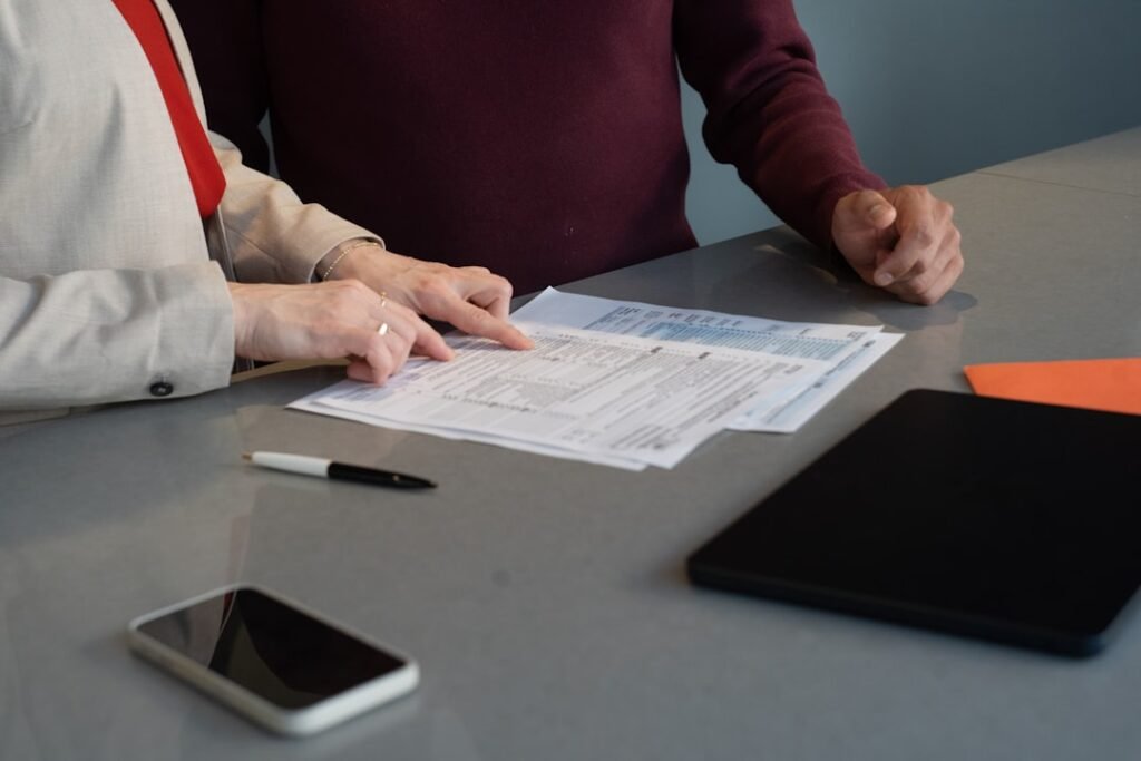 Two people reviewing a buyer's agency agreement across a table
